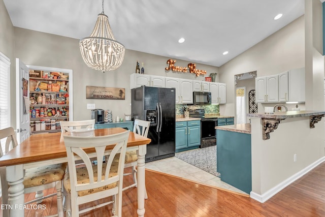 8824 Carriage House Way, Knoxville, TN 37923 - kitchen featuring black appliances, a chandelier, white cabinetry, light countertops, and lofted ceiling