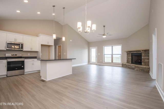 2609 Mountain Blvd, Sevierville, TN 37876 - kitchen featuring appliances with stainless steel finishes, high vaulted ceiling, a chandelier, dark countertops, and open floor plan