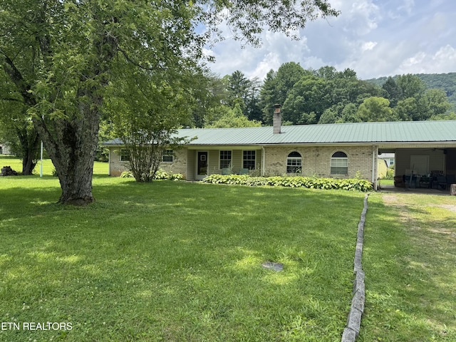 225 Spring St, Spring City, TN 37381 - ranch-style home with a chimney, a front yard, a metal roof, an attached carport, and brick siding