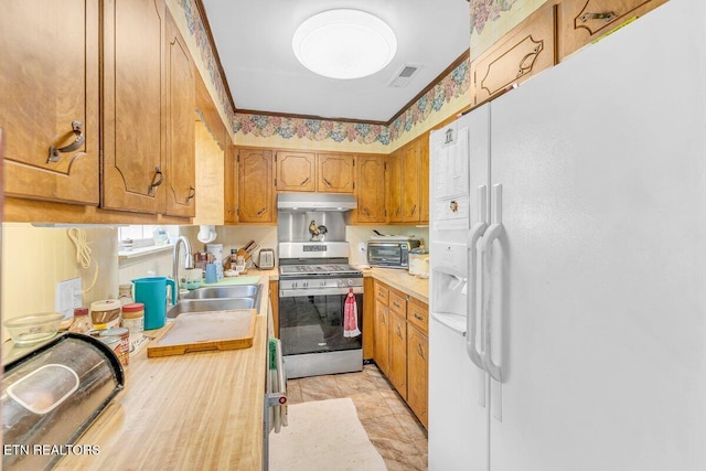 225 Spring St, Spring City, TN 37381 - kitchen with white fridge with ice dispenser, stainless steel gas range oven, light countertops, under cabinet range hood, and brown cabinetry