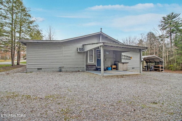 1096 Circle Dr, Jamestown, TN 38556 - back of property featuring crawl space, a wall mounted air conditioner, a carport, and gravel driveway