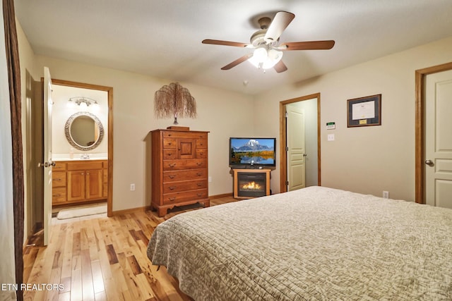 41 Crest Pl, Monterey, TN 38574 - bedroom featuring light wood-style flooring, a glass covered fireplace, connected bathroom, and a ceiling fan