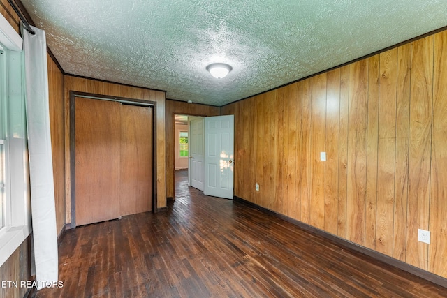 2530 Roslin Rd, Deer Lodge, TN 37726 - unfurnished bedroom featuring hardwood / wood-style floors, wooden walls, a textured ceiling, and a closet