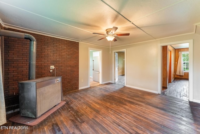 2530 Roslin Rd, Deer Lodge, TN 37726 - unfurnished living room with dark wood-style flooring, a wood stove, ceiling fan, crown molding, and a textured ceiling