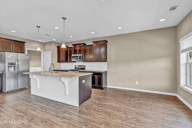 2017 Gusty Wind Ln, Knoxville, TN 37932 - kitchen with stainless steel appliances, light wood-style floors, decorative backsplash, dark brown cabinetry, and recessed lighting