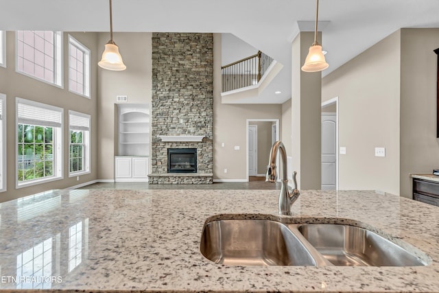 2017 Gusty Wind Ln, Knoxville, TN 37932 - kitchen with a towering ceiling, light stone countertops, decorative light fixtures, open floor plan, and a fireplace