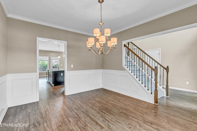 2017 Gusty Wind Ln, Knoxville, TN 37932 - empty room with wood finished floors, a chandelier, crown molding, wainscoting, and stairs