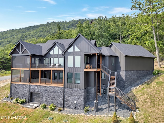 1848 Mountain Ash Way, Sevierville, TN 37876 - back of house with board and batten siding, stone siding, a forest view, stairway, and a balcony