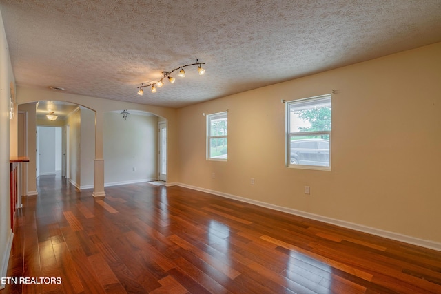 150 Ray Cross Rd, Harriman, TN 37748 - spare room featuring arched walkways, dark wood-style flooring, and a textured ceiling