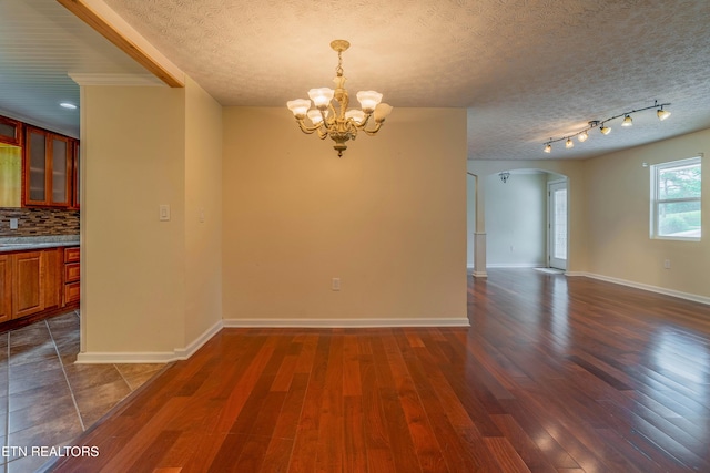 150 Ray Cross Rd, Harriman, TN 37748 - unfurnished dining area featuring arched walkways, a chandelier, dark wood-type flooring, and a textured ceiling