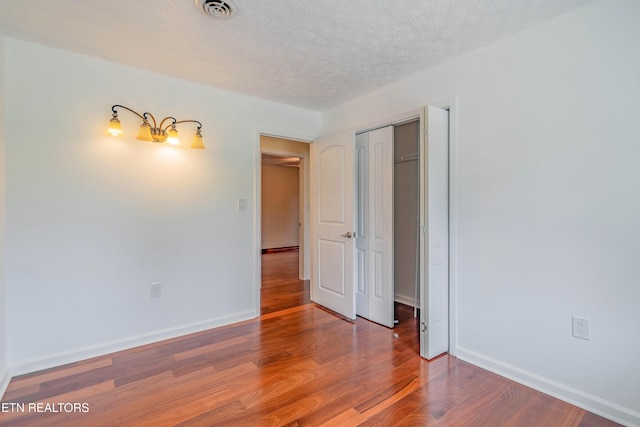 150 Ray Cross Rd, Harriman, TN 37748 - unfurnished bedroom featuring wood finished floors, a textured ceiling, and a closet