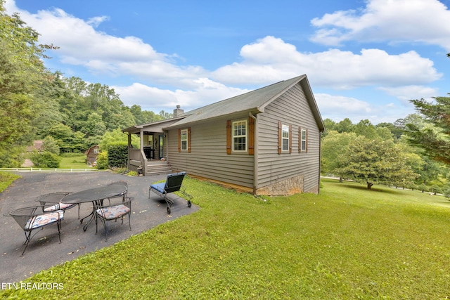 3183 Wears Dr, Sevierville, TN 37862 - rear view of house featuring a lawn, a chimney, and a patio area