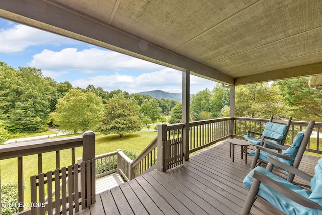 3183 Wears Dr, Sevierville, TN 37862 - wooden terrace with a mountain view, a lawn, and view of wooded area