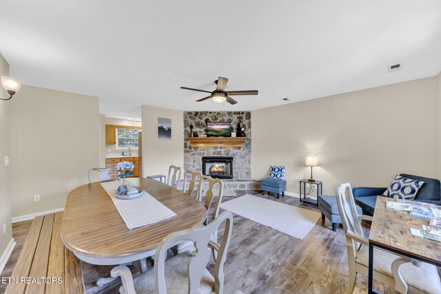3183 Wears Dr, Sevierville, TN 37862 - dining area featuring light wood finished floors, ceiling fan, and a stone fireplace