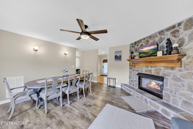 3183 Wears Dr, Sevierville, TN 37862 - dining room featuring a stone fireplace, wood finished floors, and a ceiling fan