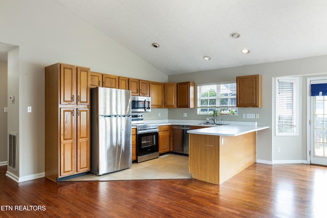 541 Pebble Creek Rd, Knoxville, TN 37918 - kitchen with appliances with stainless steel finishes, a peninsula, light wood-style flooring, light countertops, and brown cabinetry
