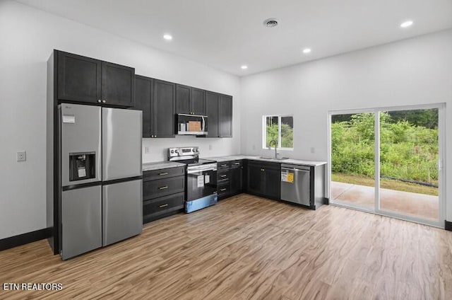1570 W Dumplin Valley Rd, Dandridge, TN 37725 - kitchen with appliances with stainless steel finishes, dark cabinets, light wood-style flooring, light countertops, and recessed lighting