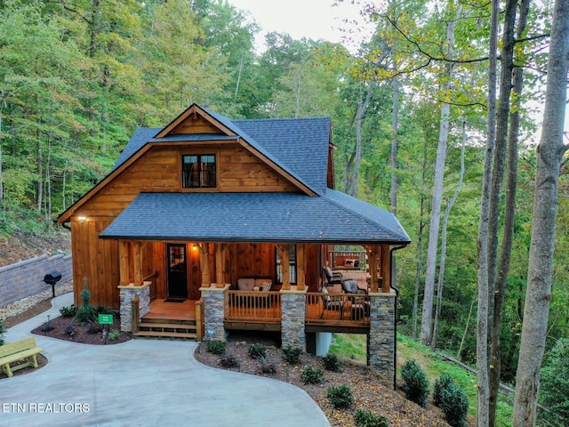 4317 Whetstone Rd, Sevierville, TN 37862 - view of front of home with a shingled roof, a porch, a view of trees, and board and batten siding