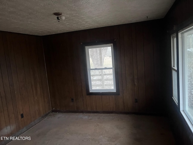 332 Ridge Rd, Lancing, TN 37770 - unfurnished room with healthy amount of natural light, wooden walls, and a textured ceiling