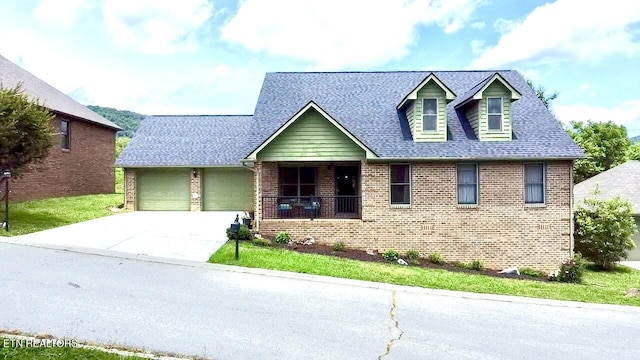 135 Whisper Creek Rd, Lafollette, TN 37766 - cape cod-style house featuring brick siding, an attached garage, concrete driveway, roof with shingles, and a porch