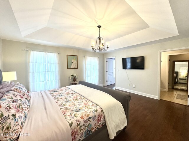 135 Whisper Creek Rd, Lafollette, TN 37766 - bedroom with a tray ceiling, dark wood-style flooring, and a chandelier