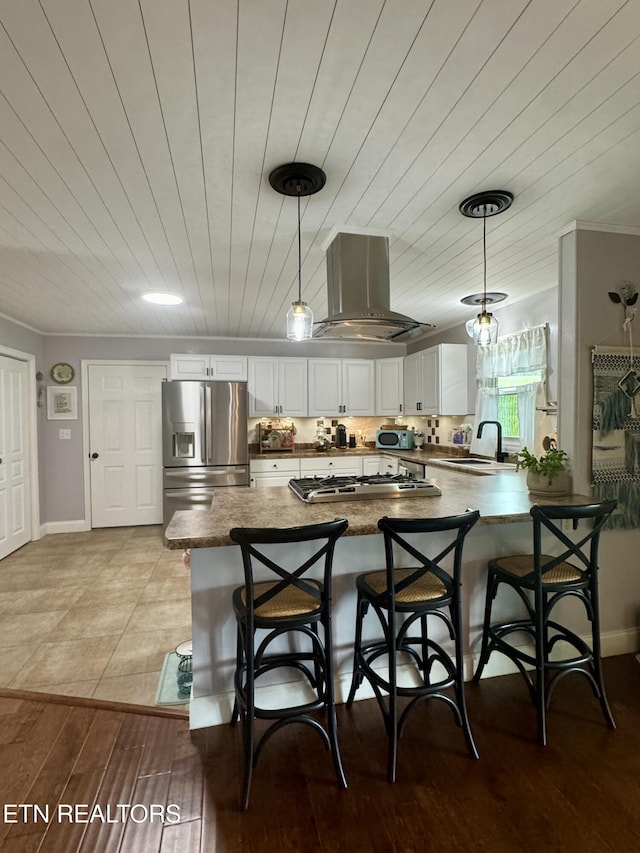 135 Whisper Creek Rd, Lafollette, TN 37766 - kitchen featuring appliances with stainless steel finishes, island range hood, a peninsula, white cabinetry, and crown molding