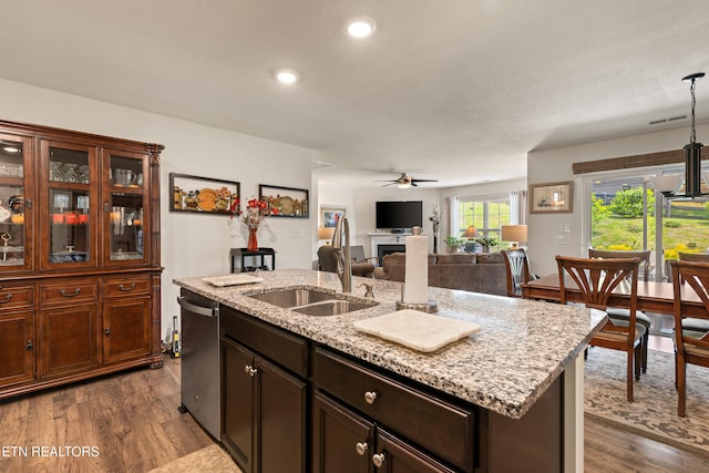 1426 Mesquite Dr, Sevierville, TN 37876 - kitchen featuring dishwasher, a ceiling fan, dark wood-type flooring, a fireplace, and a kitchen island with sink