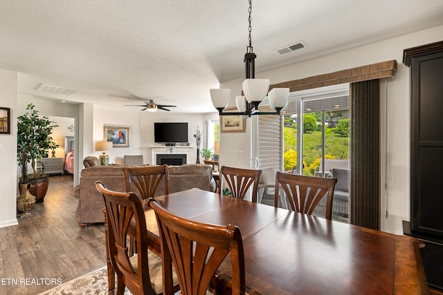 1426 Mesquite Dr, Sevierville, TN 37876 - dining space featuring a fireplace, healthy amount of natural light, wood finished floors, a ceiling fan, and a textured ceiling