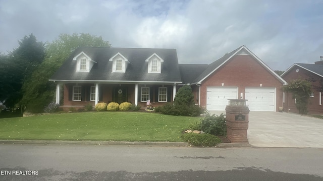 1843 River Vista Cir, Sevierville, TN 37876 - cape cod house with concrete driveway, a front yard, an attached garage, brick siding, and a porch