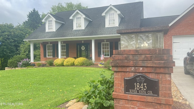 1843 River Vista Cir, Sevierville, TN 37876 - cape cod house with a front yard, covered porch, a shingled roof, and brick siding