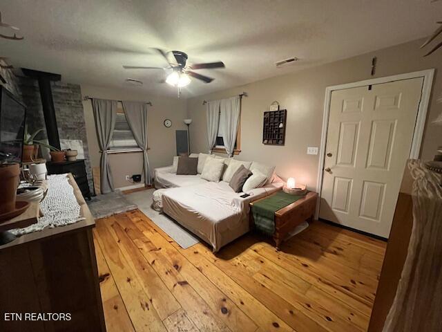 4016 Retro Hughes Rd, Graysville, TN 37338 - living room with a wood stove, a ceiling fan, and hardwood / wood-style floors