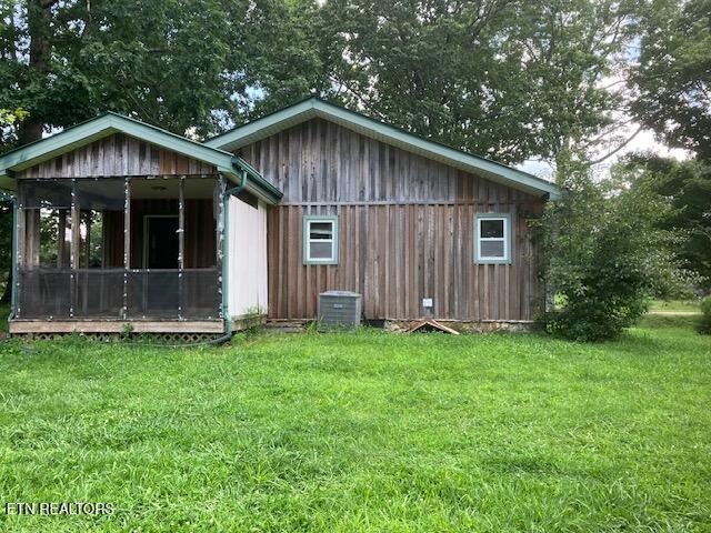 4016 Retro Hughes Rd, Graysville, TN 37338 - back of house with a sunroom and a lawn