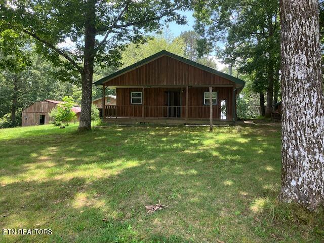 4016 Retro Hughes Rd, Graysville, TN 37338 - chalet / cabin with a front lawn and a porch