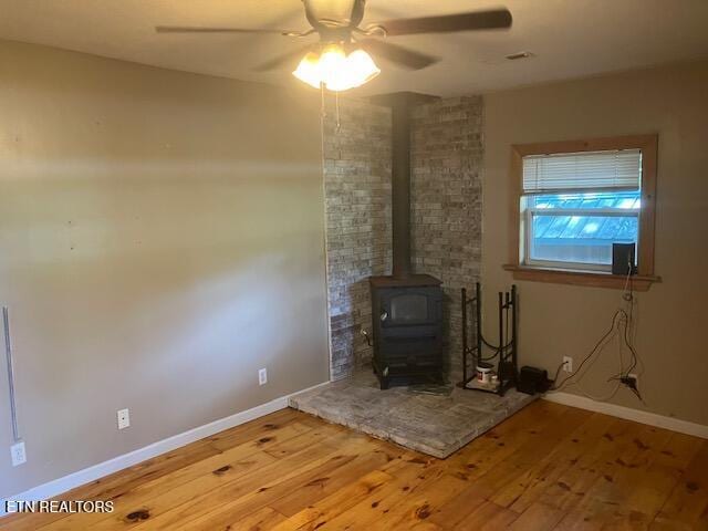 4016 Retro Hughes Rd, Graysville, TN 37338 - detailed view of a wood stove, wood finished floors, and a ceiling fan