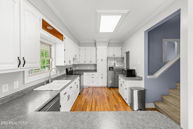 171 Wrenwood Way, Greenback, TN 37742 - kitchen featuring appliances with stainless steel finishes, light wood-style floors, ornamental molding, white cabinetry, and dark countertops