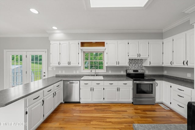 171 Wrenwood Way, Greenback, TN 37742 - kitchen featuring appliances with stainless steel finishes, dark countertops, ornamental molding, white cabinets, and a peninsula