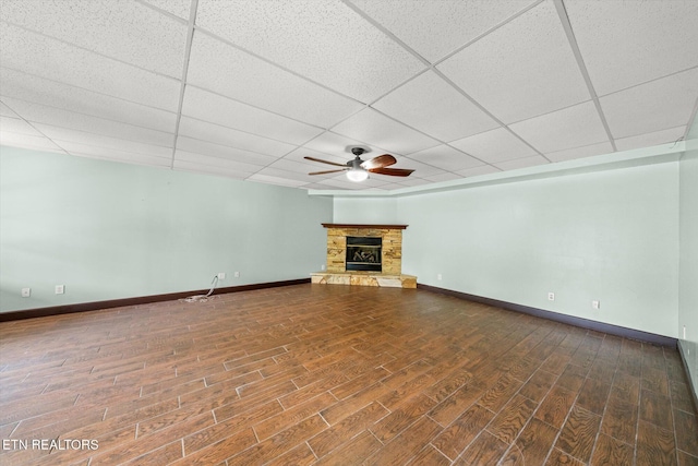 171 Wrenwood Way, Greenback, TN 37742 - unfurnished living room featuring a ceiling fan, a drop ceiling, wood finished floors, and a stone fireplace
