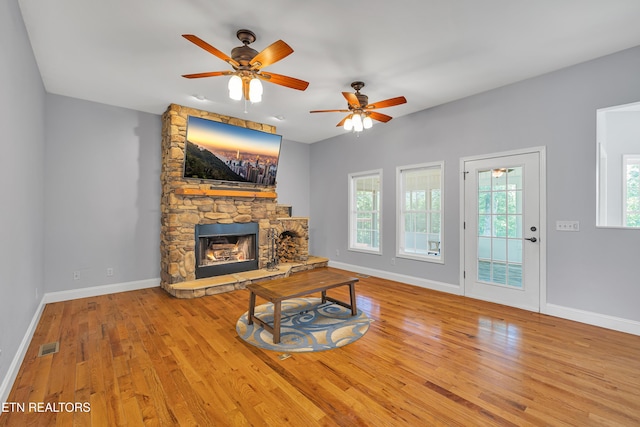 4040 Roundtop Dr, Sevierville, TN 37862 - living area with wood finished floors, a stone fireplace, and a ceiling fan