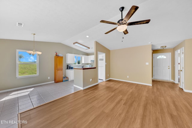 8040 Walt Way, Corryton, TN 37721 - unfurnished living room with ceiling fan, light wood-style flooring, vaulted ceiling, plenty of natural light, and a chandelier