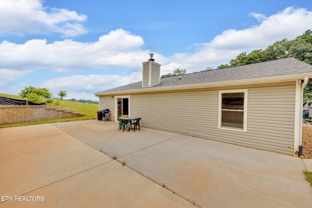 8040 Walt Way, Corryton, TN 37721 - back of property with a patio, a chimney, and roof with shingles