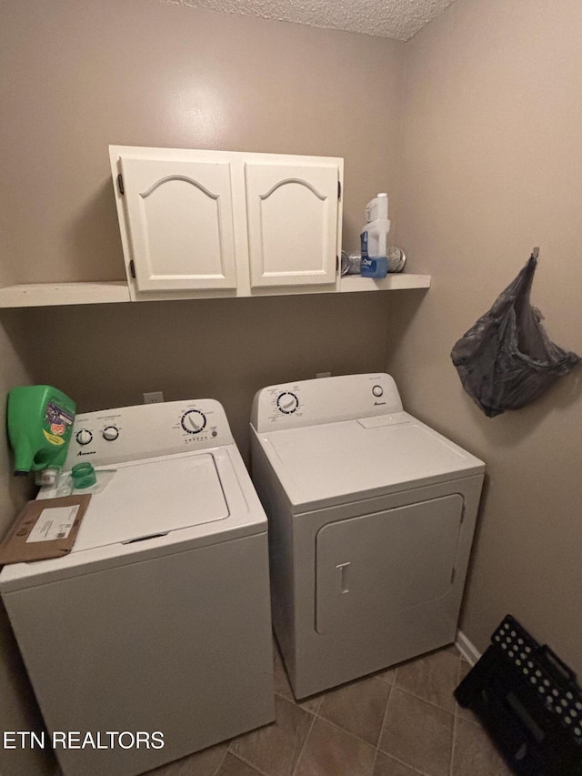 8022 Intervale Way, Powell, TN 37849 - laundry area featuring washer and clothes dryer, cabinet space, a textured ceiling, and dark tile patterned flooring