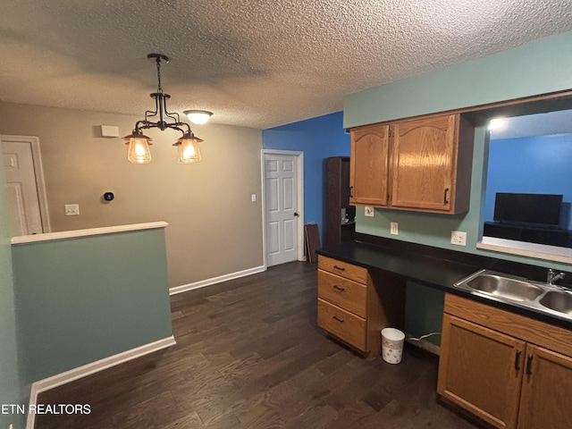 8022 Intervale Way, Powell, TN 37849 - kitchen featuring dark wood-style flooring, dark countertops, a textured ceiling, pendant lighting, and brown cabinets