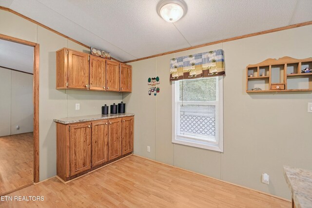 4334 Big Creek Rd, Hartford, TN 37753 - kitchen featuring crown molding, light wood finished floors, lofted ceiling, brown cabinets, and a textured ceiling