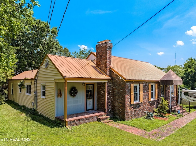 5400 Parkdale Rd, Knoxville, TN 37912 - view of front of house with a chimney, a front lawn, a metal roof, and brick siding