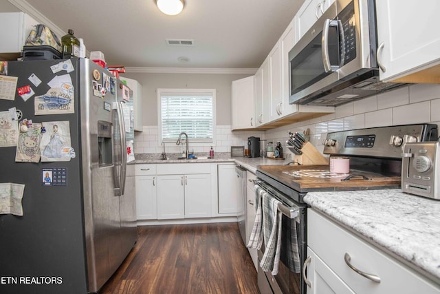 1359 Byrd Cir, Kingston, TN 37763 - kitchen with appliances with stainless steel finishes, ornamental molding, white cabinetry, dark wood-type flooring, and tasteful backsplash