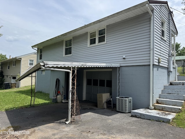 2101 NW Chillicothe St, Knoxville, TN 37921 - back of house with asphalt driveway, an attached garage, and a yard