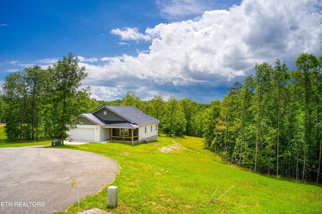 760 Rockview Rd, Jamestown, TN 38556 - view of front of house featuring asphalt driveway, an attached garage, a front yard, and a view of trees