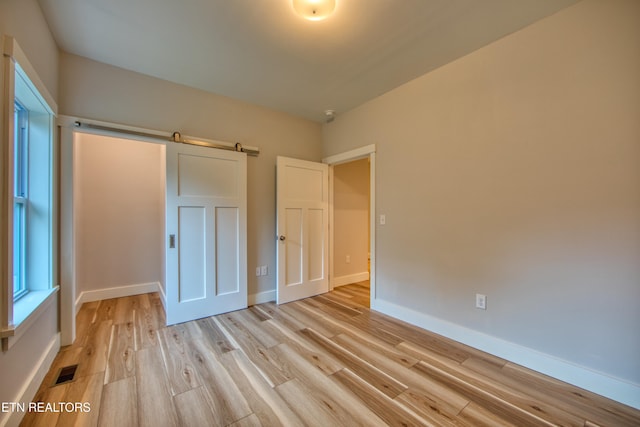 760 Rockview Rd, Jamestown, TN 38556 - unfurnished bedroom featuring light wood-type flooring and a barn door