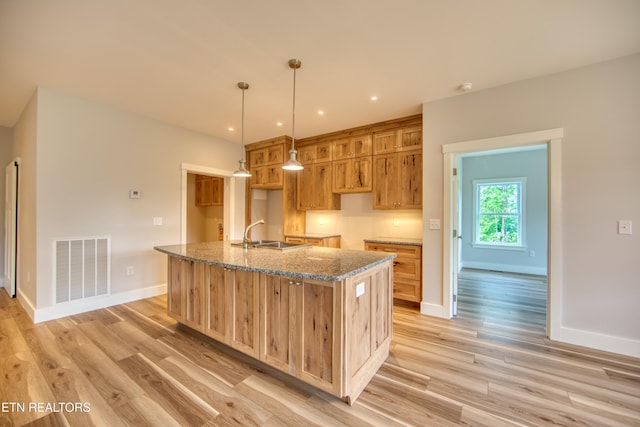 760 Rockview Rd, Jamestown, TN 38556 - kitchen with light wood-type flooring, a kitchen island with sink, stone countertops, and decorative light fixtures