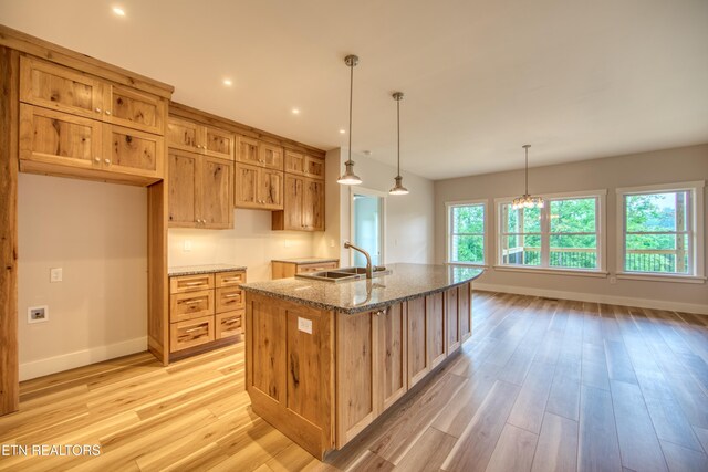 760 Rockview Rd, Jamestown, TN 38556 - kitchen featuring light wood-type flooring, a center island with sink, stone counters, a chandelier, and hanging light fixtures